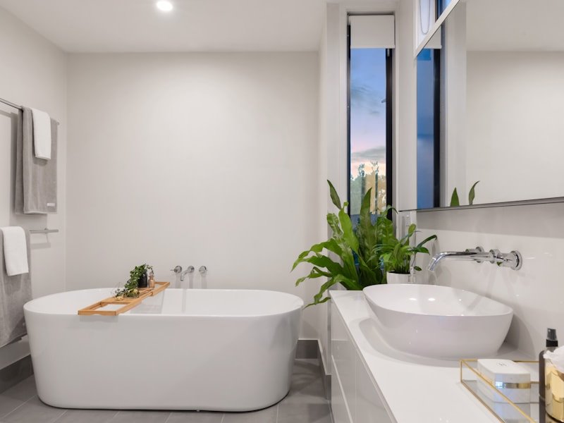 Clean, bright bathroom with freestanding tub and accessible-ready grab bar locations.